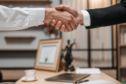 Professional handshake between physician and legal advisor in an office setting